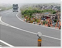 瓦礫の山となった道路脇